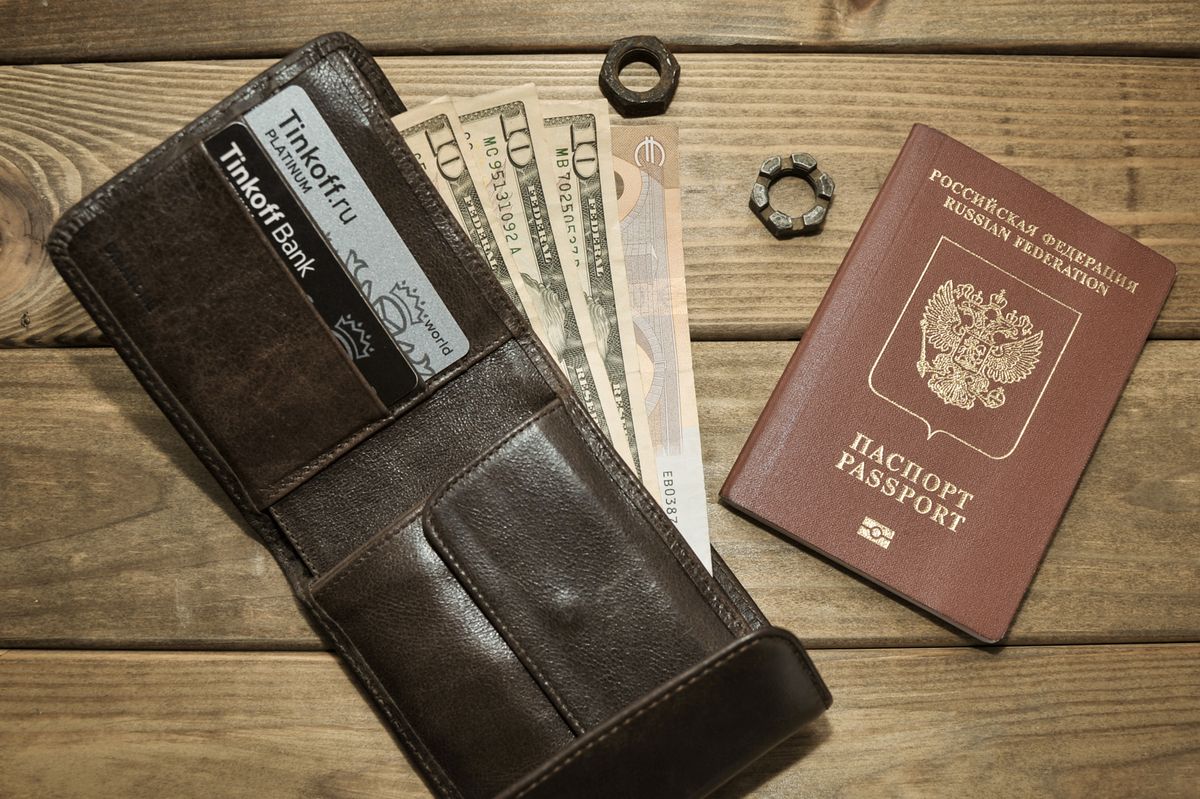 Ví da với tiền đô la Mỹ và hộ chiếu — chi phí bảo hiểm du lịch Schengen tính theo ngày và gói
